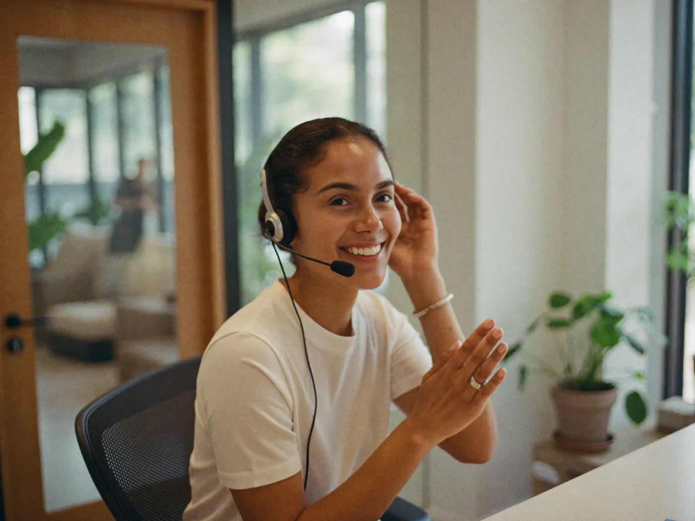 A window and door company receptionist answering a homeowner call in a bright showroom office